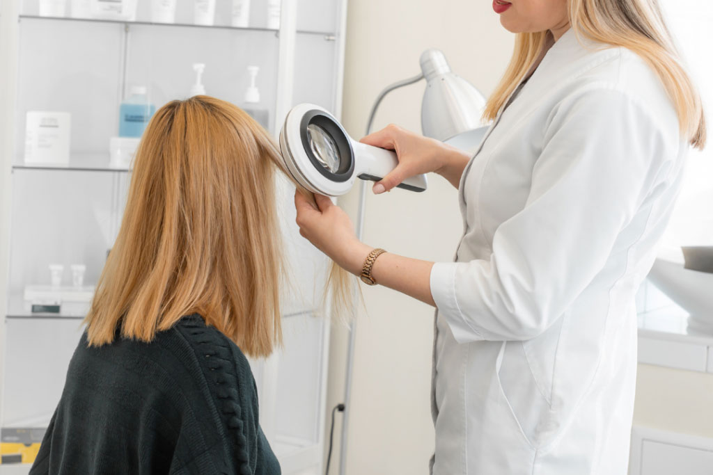 cheerful african american hairstylist and client looking away in salon